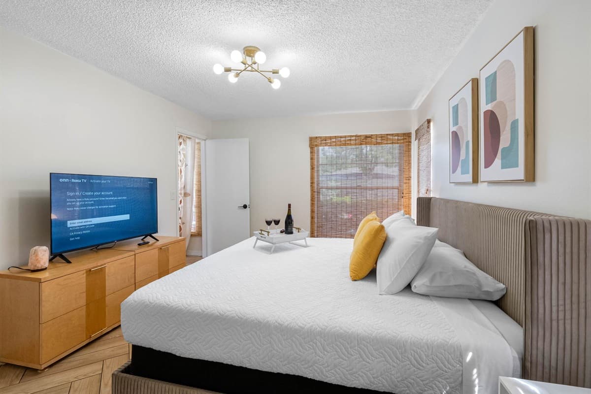 This sun-filled bedroom is designed for rest and relaxation. With a luxurious upholstered headboard, fresh white linens, and golden yellow pillows, it’s the perfect mix of comfort and style.