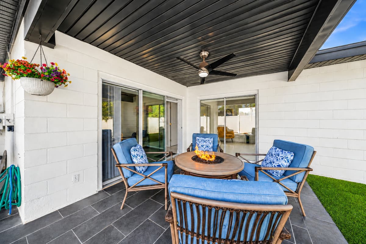 Inviting outdoor entertainment space with fire table, lounge seating, and patio access.