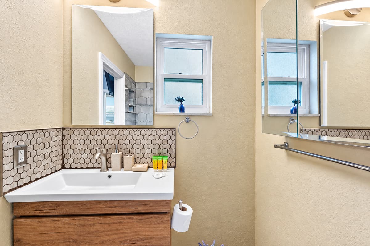 Updated bathroom with a modern vanity and elegant hex-tile shower.