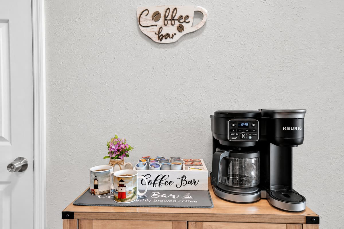 A real coffee bar, not a lonely machine on the counter: dual brewer for pods or a full pot, mugs lined up and everything within arm's reach. Whoever wakes first gets the quiet porch and the first cup.