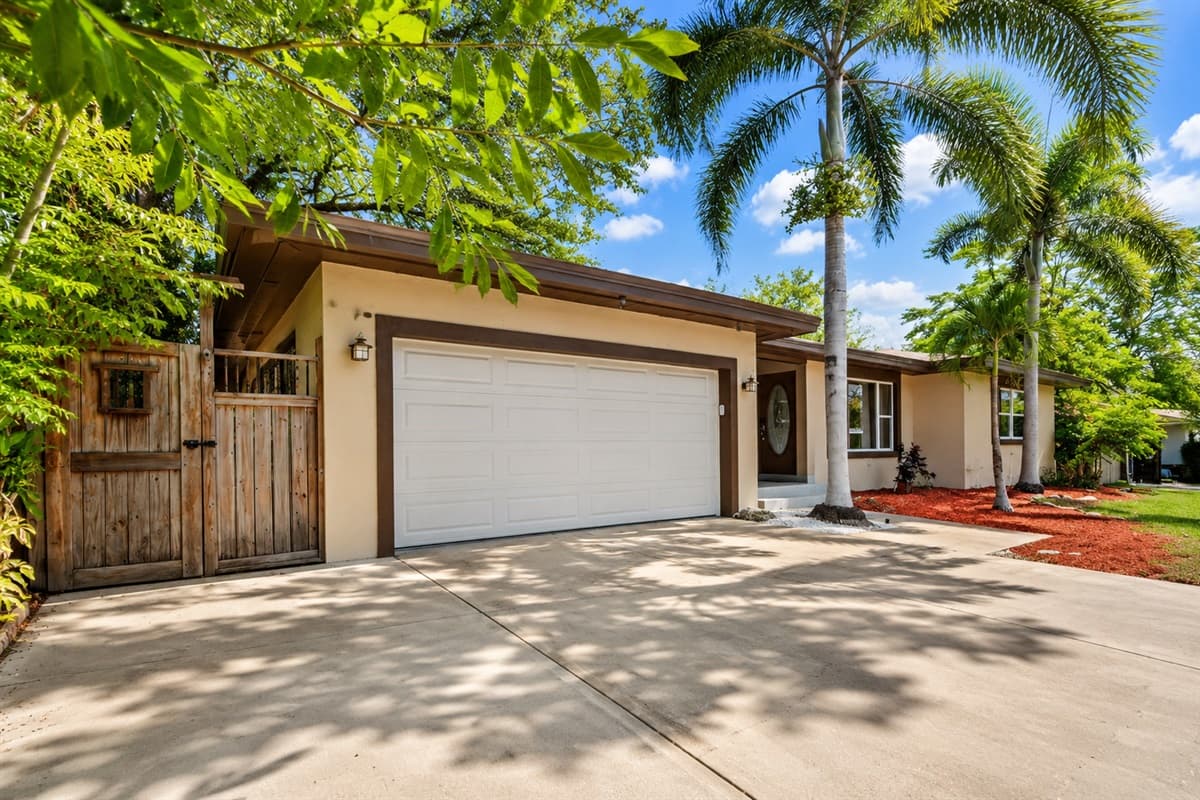 Spacious driveway with ample parking and beautiful palm tree landscaping.