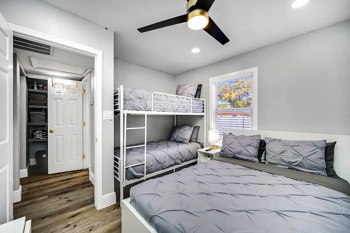 Immaculate bedroom with single bunkbed, queen sized bed, closet and smart TV.