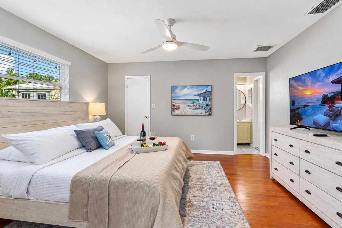 A tranquil haven featuring a stylish wood bed frame, fresh linens, and calming sea-inspired decor.