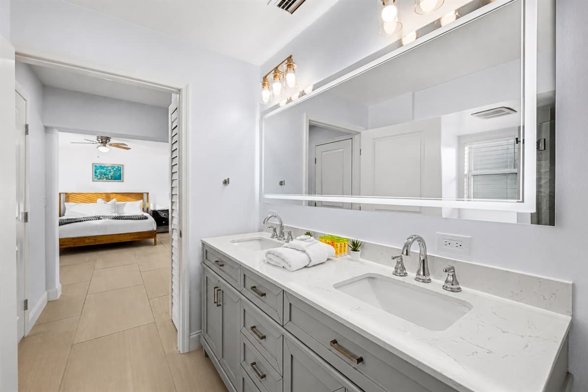 Stylish bathroom vanity with illuminated mirror and direct access to the bedroom suite.