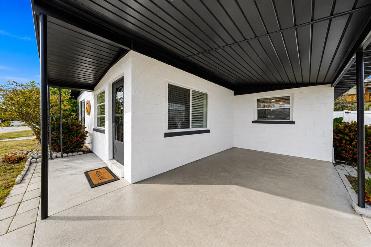 Spacious covered carport and front patio area with convenient sheltered entry access.