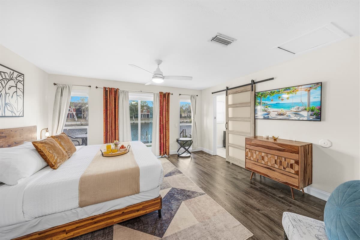 Stylish primary bedroom offering plenty of space, natural light, and tranquil water views.