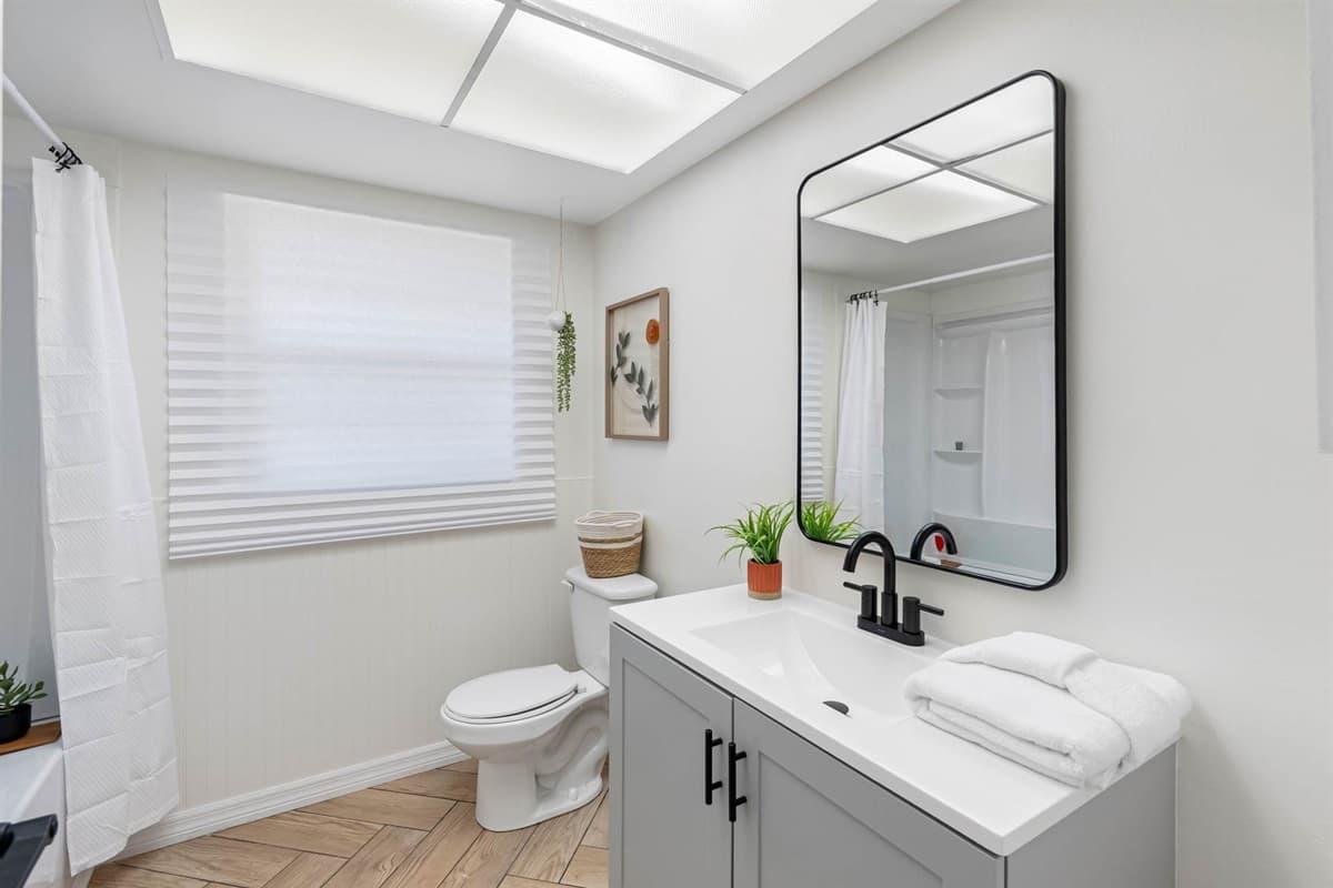 Designed with comfort in mind, this bright bathroom features soft neutral tones, generous lighting, and a modern shower area—ideal for guests who appreciate clean design.
