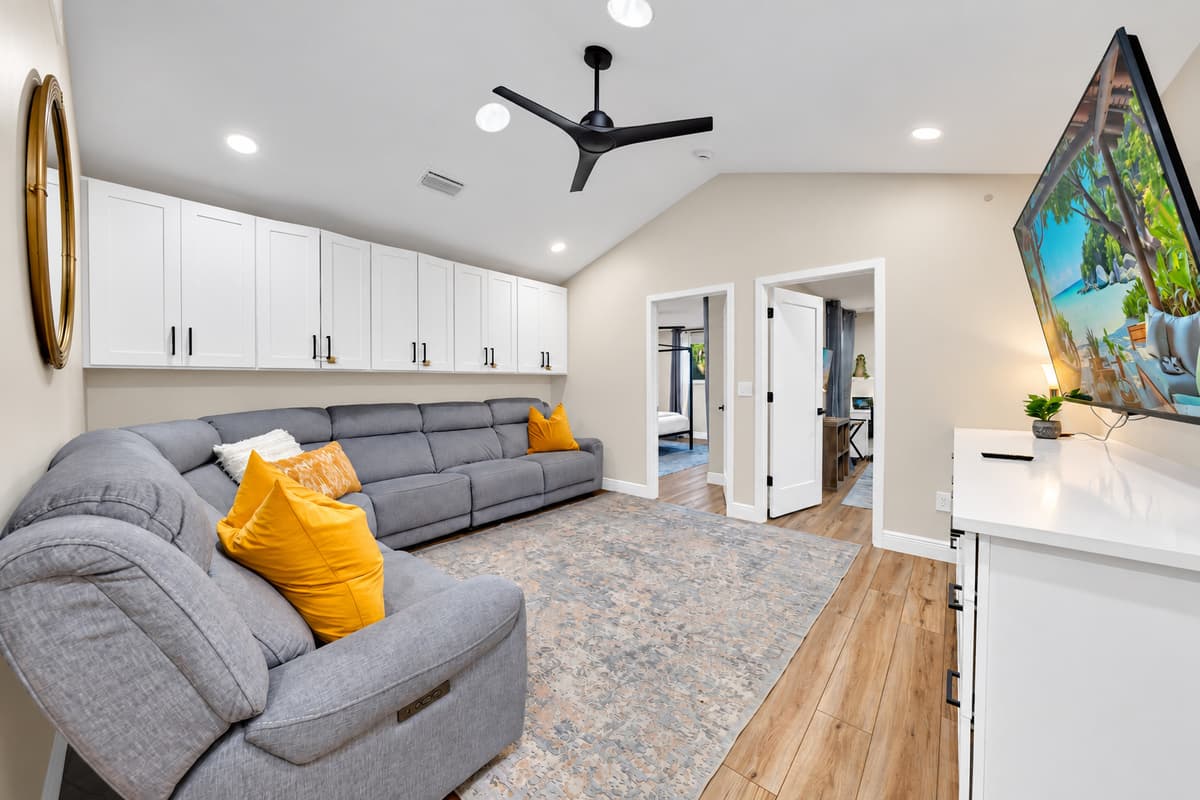 The second lounge, for when sixteen is too many. Deep sectional, vaulted ceiling and a door that closes — somewhere to read, nap or watch something nobody else voted for.