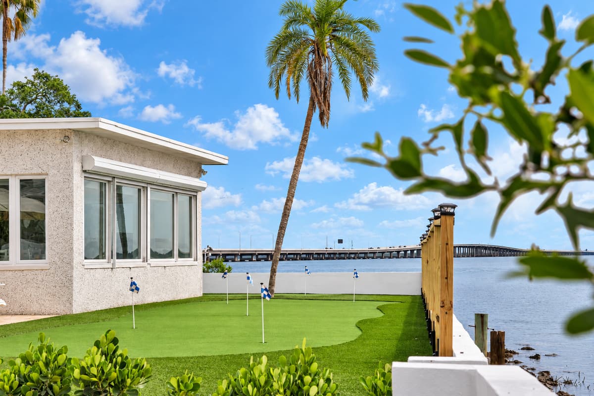 Palms, putting green and the bridge. A tall palm, the sunroom and the bay bridge in the distance. Every corner of this yard looks like a postcard.