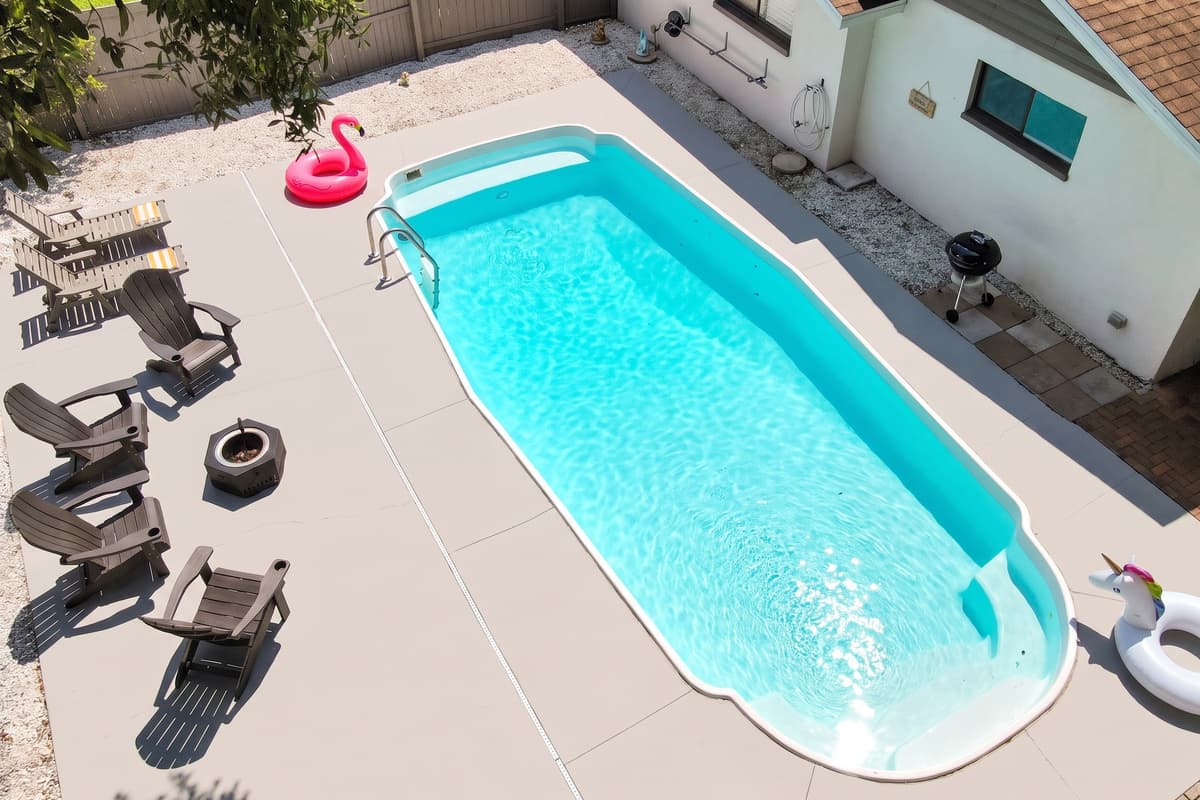 Picture the loungers taken: someone reading, someone half asleep, someone yelling to watch a cannonball. Shade when you want it, sun when you don't, and the kitchen only a few steps away for the next round of drinks.