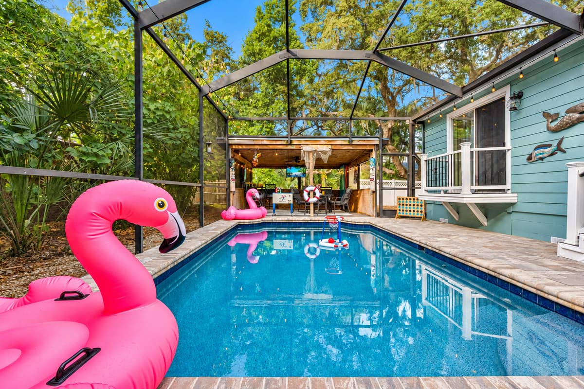 The pool area offers a serene retreat with lush landscaping, warm lighting, and a spacious deck ideal for lounging or swimming.