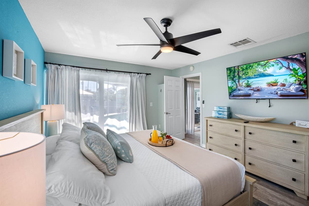 Unwind in this serene king suite with a soothing blue accent wall, large mirror, and spa-like ensuite bathroom.