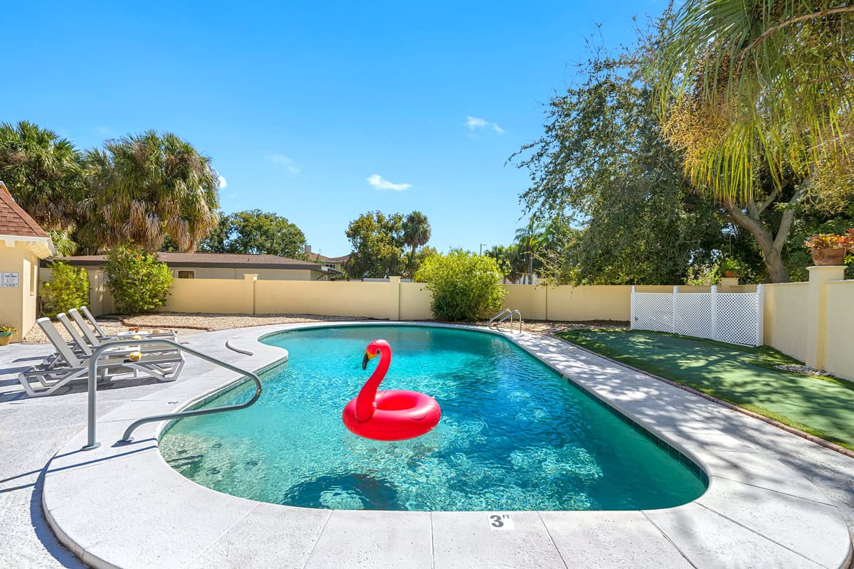 This fully fenced backyard features a sparkling pool, shaded lounge seating, and a BBQ area — your very own slice of paradise in Tampa.