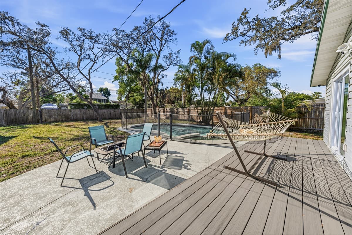 Outdoor lounge area with seating, hammock, and poolside space—perfect for enjoying sunny Florida days.