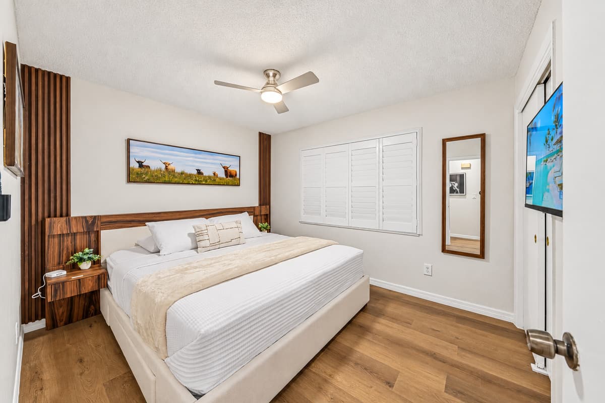 Comfortable king bedroom with warm wood accents, stylish décor, and a cozy, inviting feel 