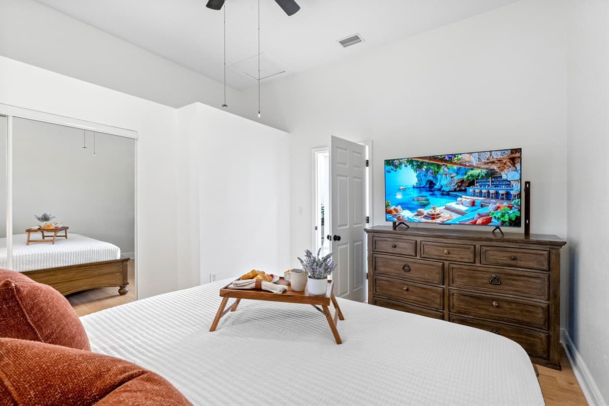 This cozy yet airy bedroom features a statement wood headboard, soft textiles, and plenty of natural light for a relaxing atmosphere.