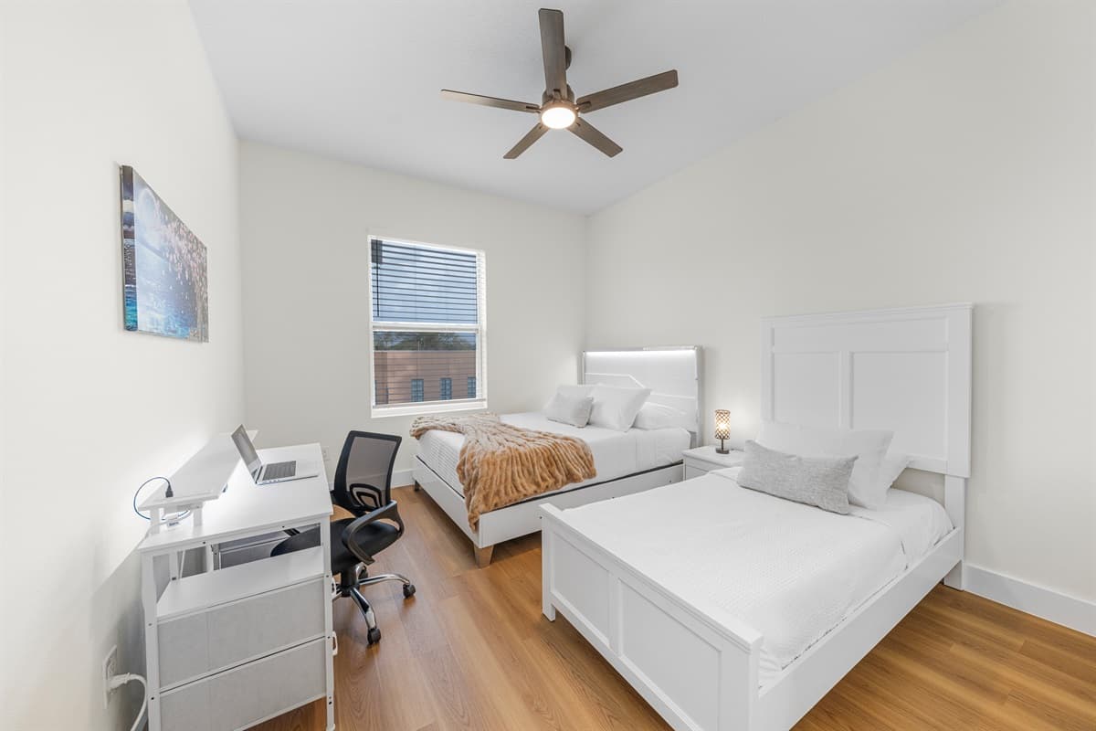 Comfortable bedroom with two beds and workspace—great for extended stays.