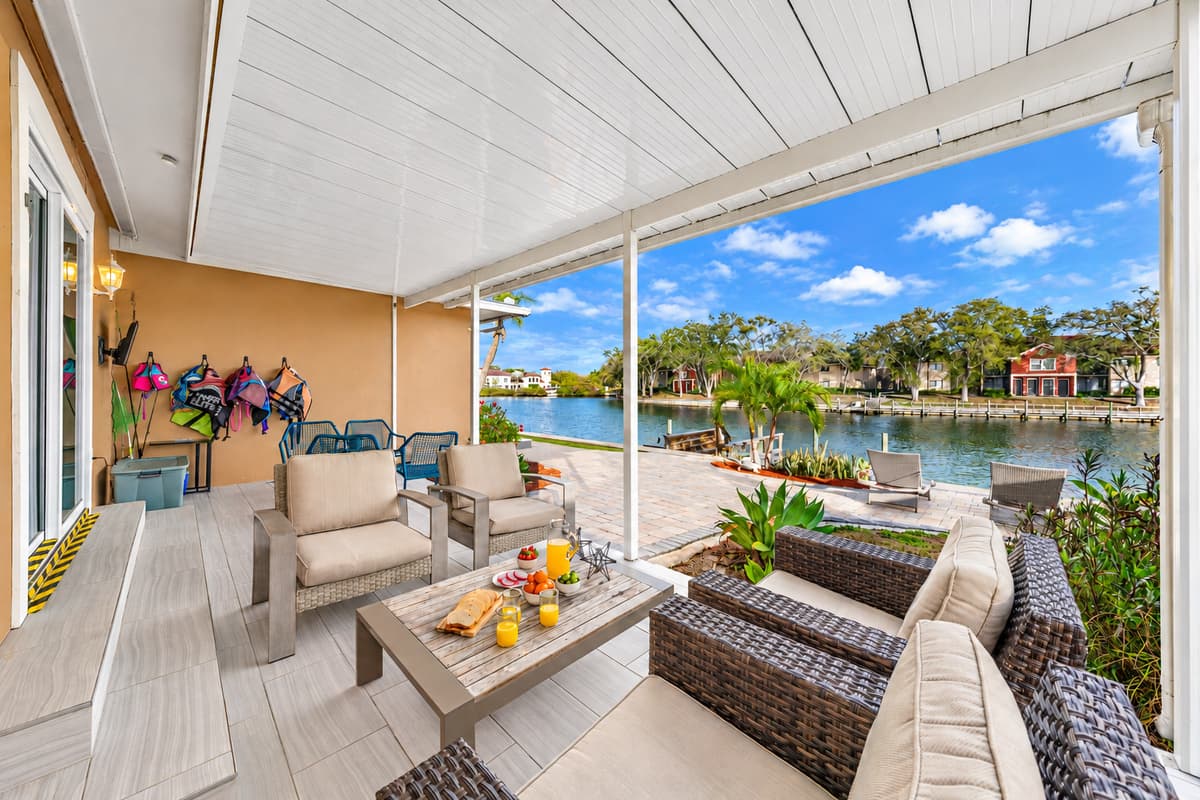 Relax on the covered waterfront patio with comfortable outdoor seating and beautiful lake views.