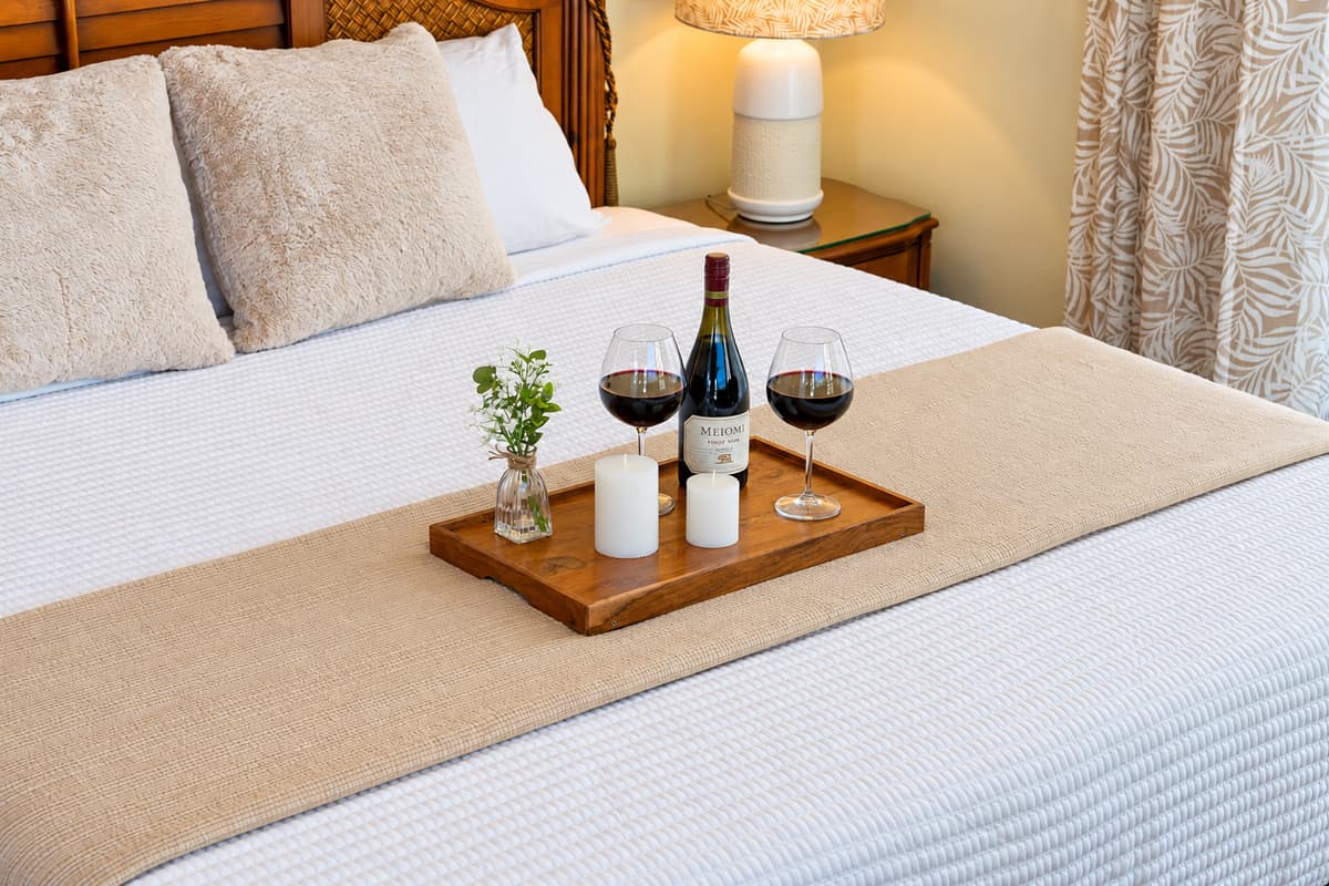 Enjoy restful nights in this tranquil master bedroom complete with a ceiling fan, cozy lighting, and a comfortable king-sized bed.
