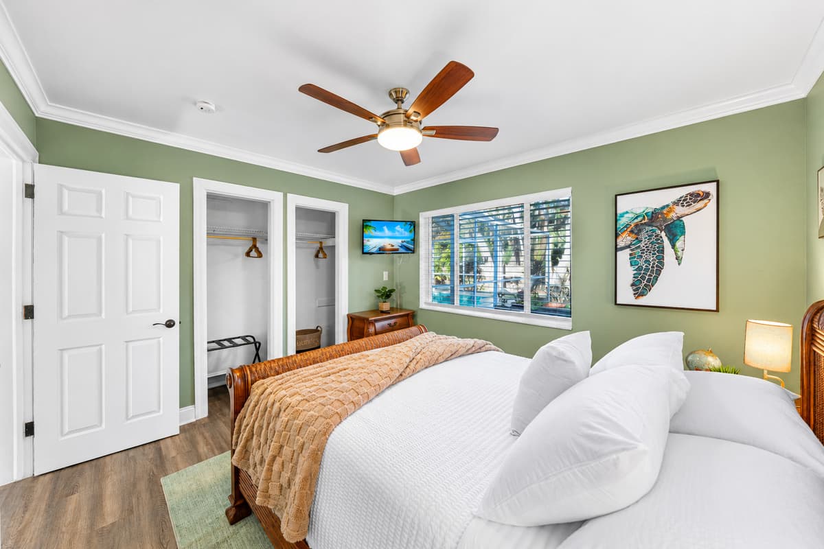 A serene queen bedroom with soft lighting, comfortable furnishings, and a cozy atmosphere.