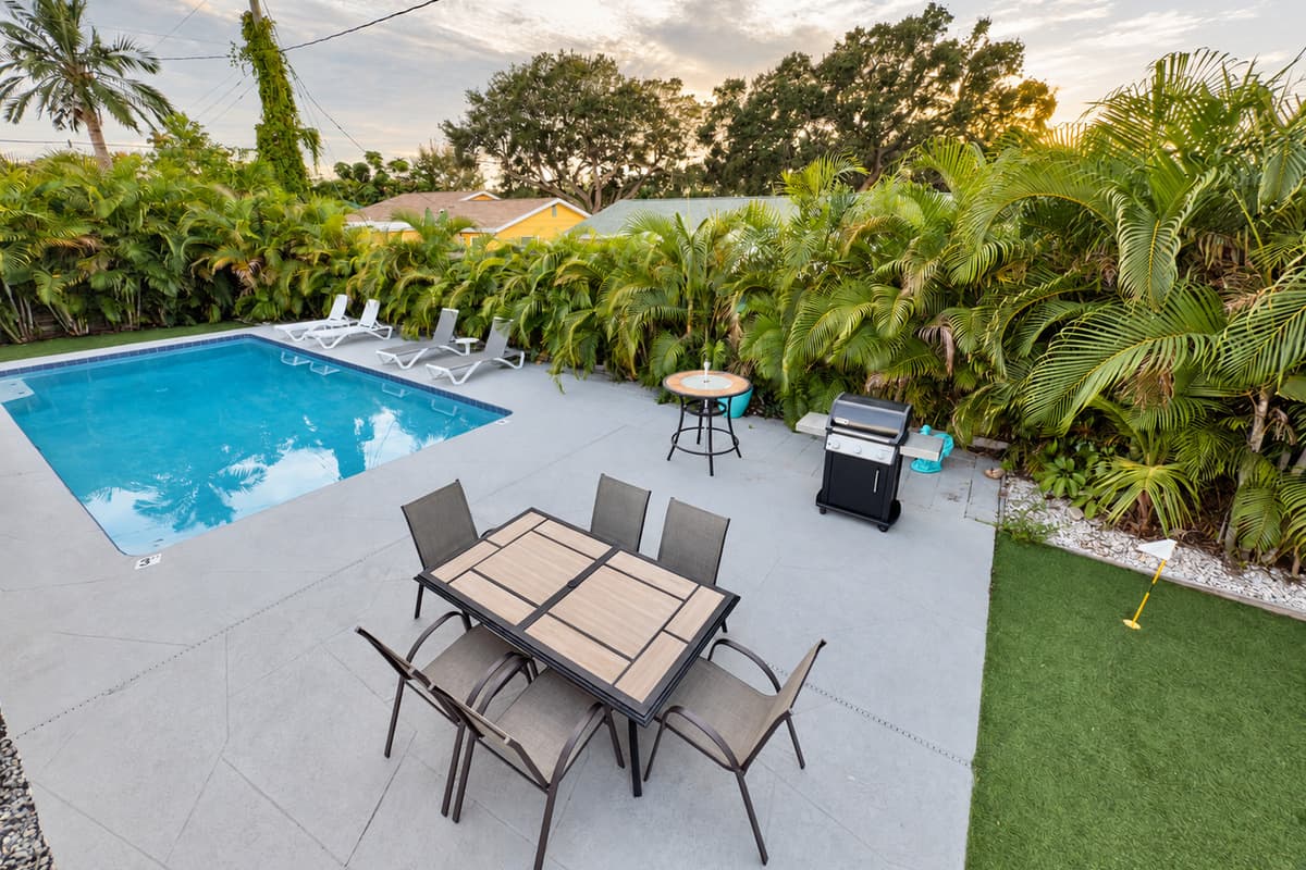 Enjoy a spacious backyard oasis featuring a sparkling private pool, outdoor dining area, and a modern grill for family cookouts.