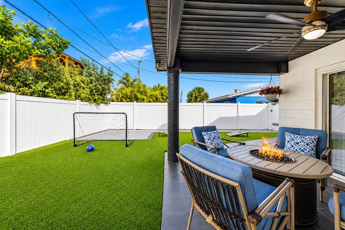 Backyard patio view featuring the fire table lounge area and outdoor recreation space.
