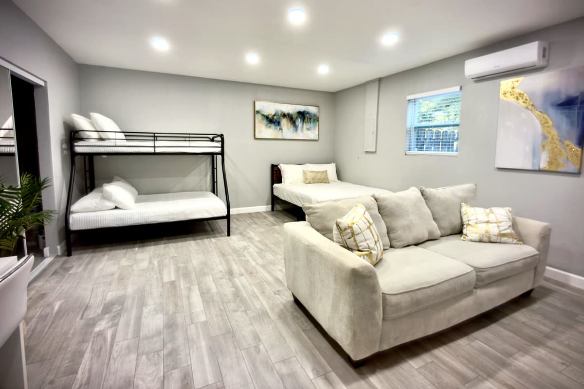 This beautifully appointed bedroom boasts a queen-size bed, a bunk bed, and a comfortable seating area, creating a warm and welcoming atmosphere.