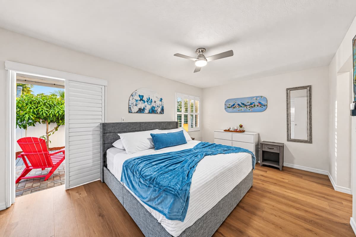Cozy bedroom with king bed, bright natural light, and direct access to outdoor seating 