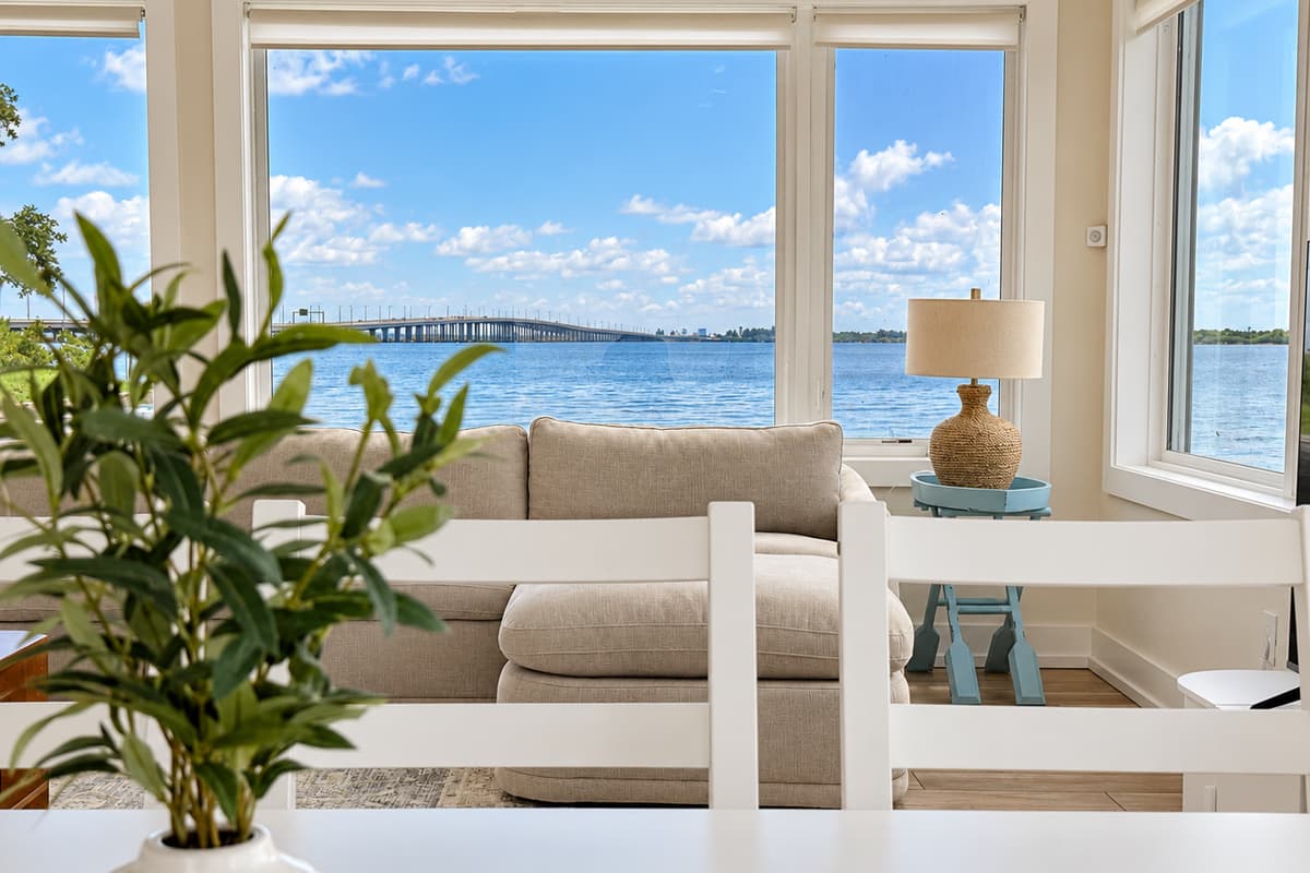Waterfront living room with comfortable seating and wide water views.