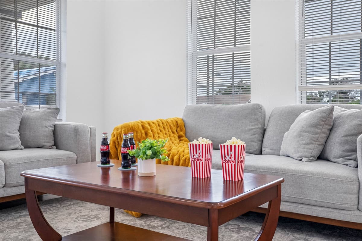Relax in this beautifully furnished living room featuring modern accents, natural light, and plenty of seating for everyone in your group.