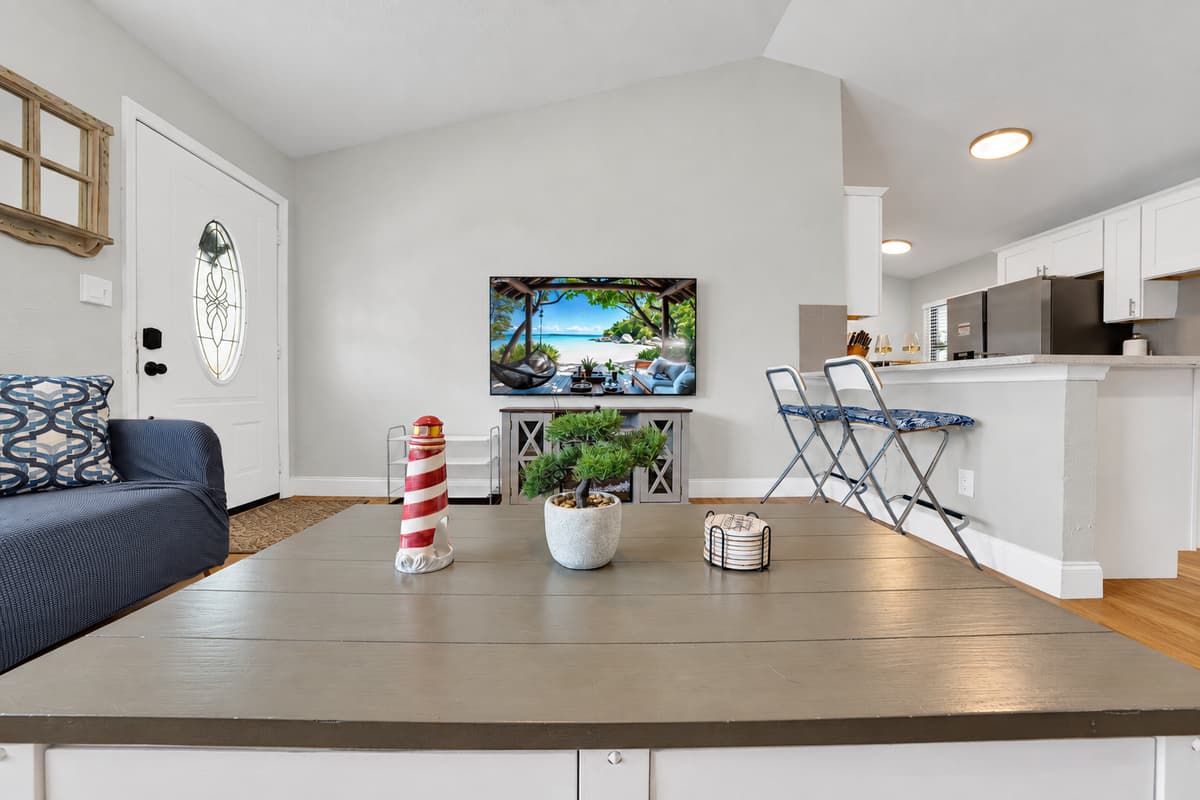 From this counter you can see the TV, the sofas and the front door at once. Whoever is chopping, pouring or reheating leftovers stays in the middle of the conversation instead of banished to another room.