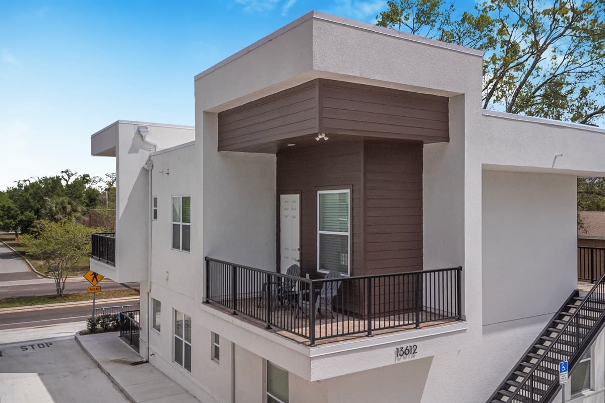 Your private 2nd-floor entrance with a spacious covered patio. Kick back in the chairs and enjoy the tree-lined street views below.