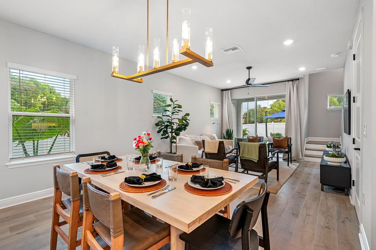 The dining area features a spacious table set for six, its rich wood finish and elegant design lending a touch of timeless charm to the room.
