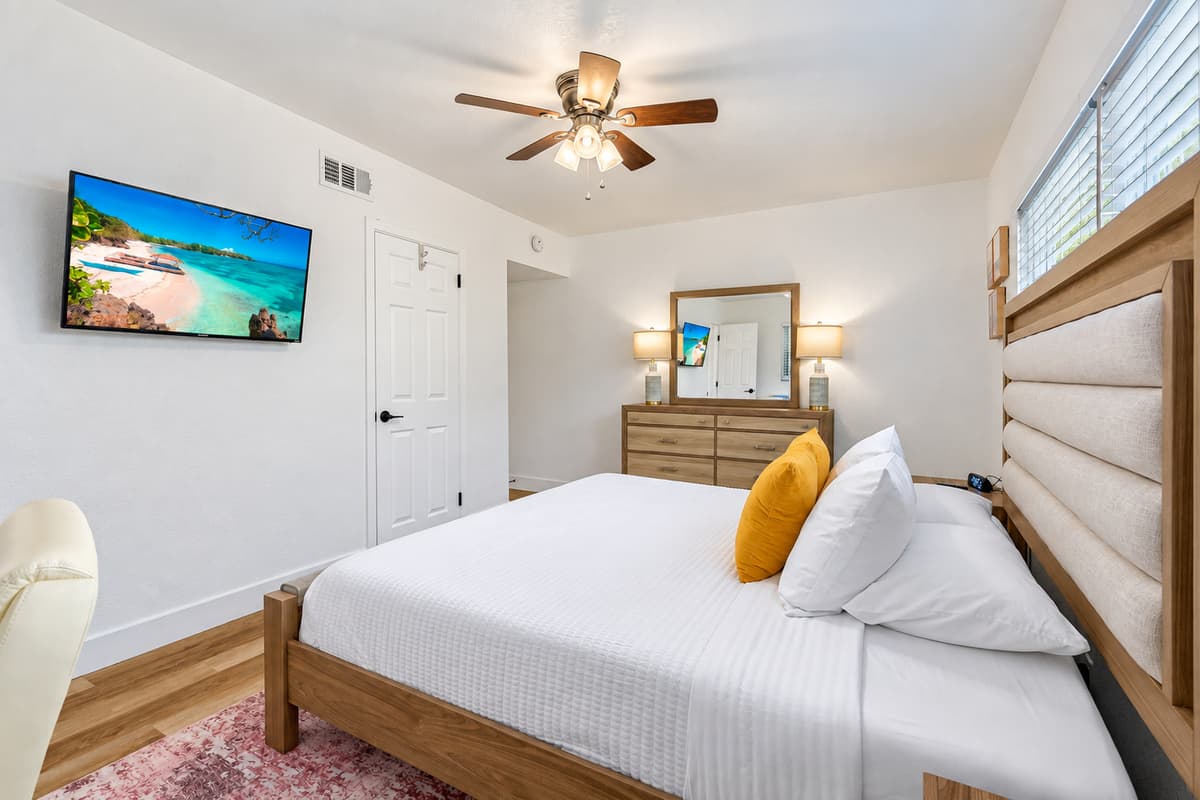 Bright, modern, and peaceful—this guest bedroom features a cozy queen bed, work desk, and plenty of natural light for a perfect stay.