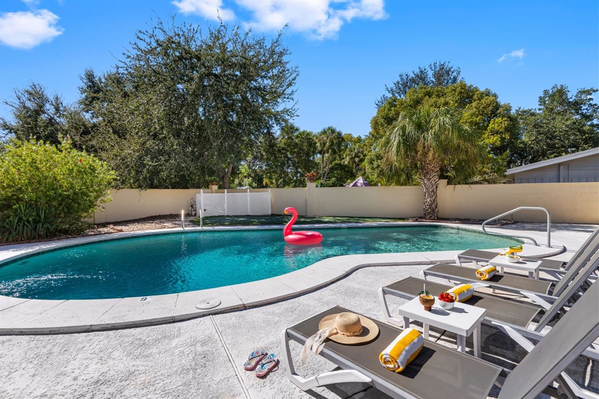 Unwind in this private backyard oasis featuring a sparkling pool, comfy loungers, and lush tropical landscaping — perfect for soaking up the Florida sunshine.