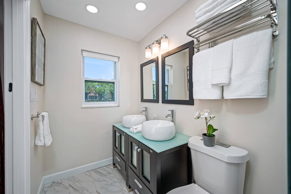 Beautiful bathroom equipped with his and hers sink, toilet, and shower. Enjoy a relaxing bath after a long day of travel from your home to your home away from home. If you think this property is for you, send us an inquiry right away!