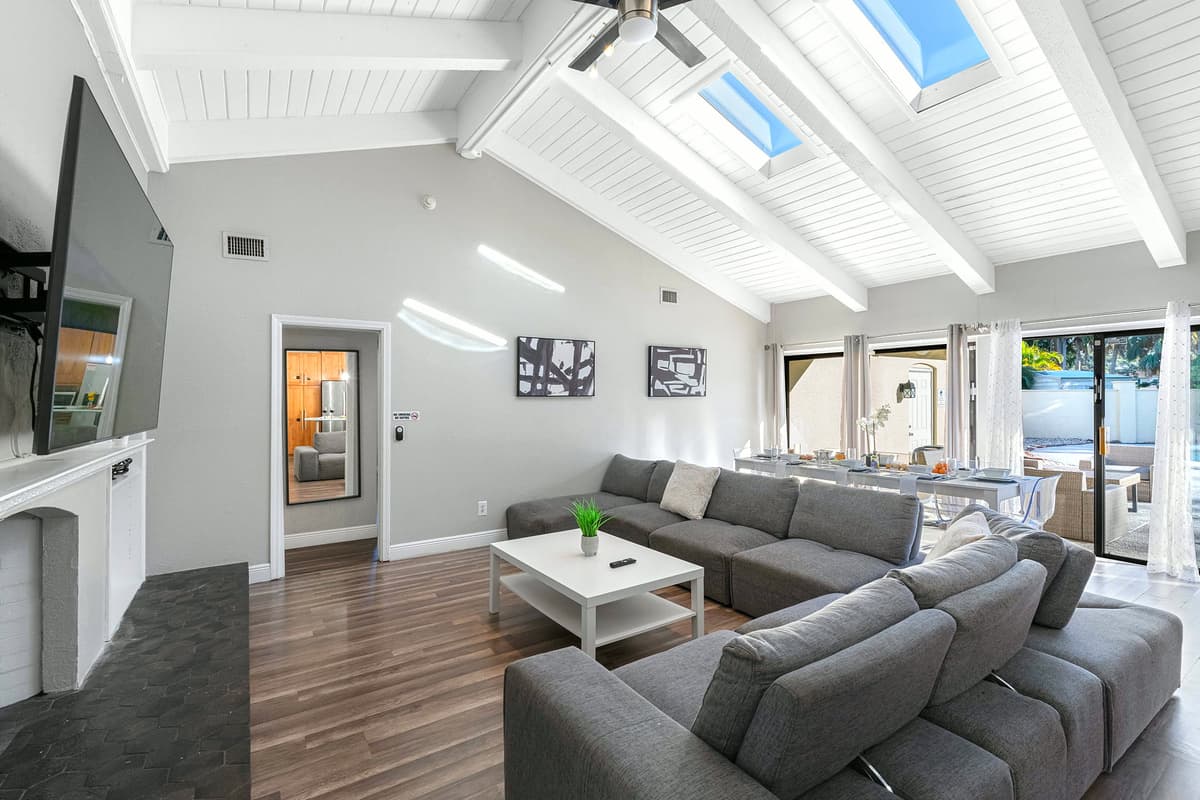 This stylish living room features vaulted ceilings, skylights, and a spacious sectional sofa that invites you to relax in comfort.