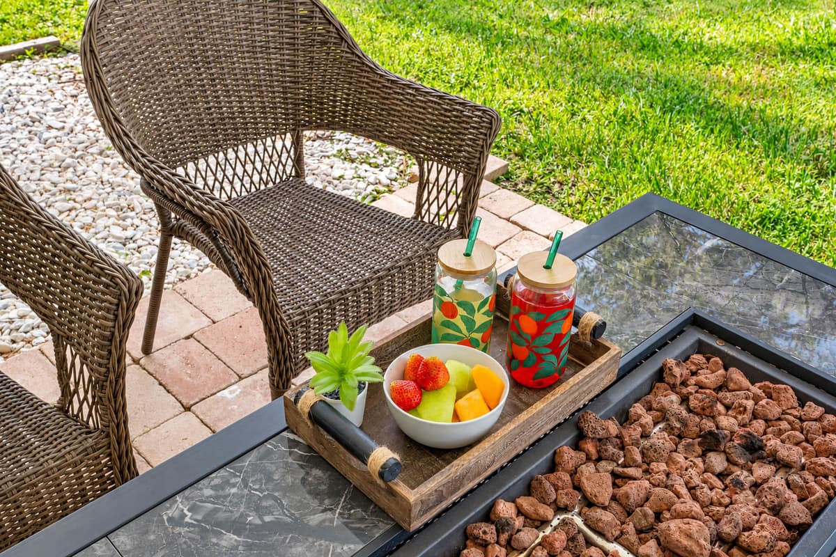Comfortable wicker seating and a stylish dining set make this patio feel like an outdoor living room, complete with calming water views.