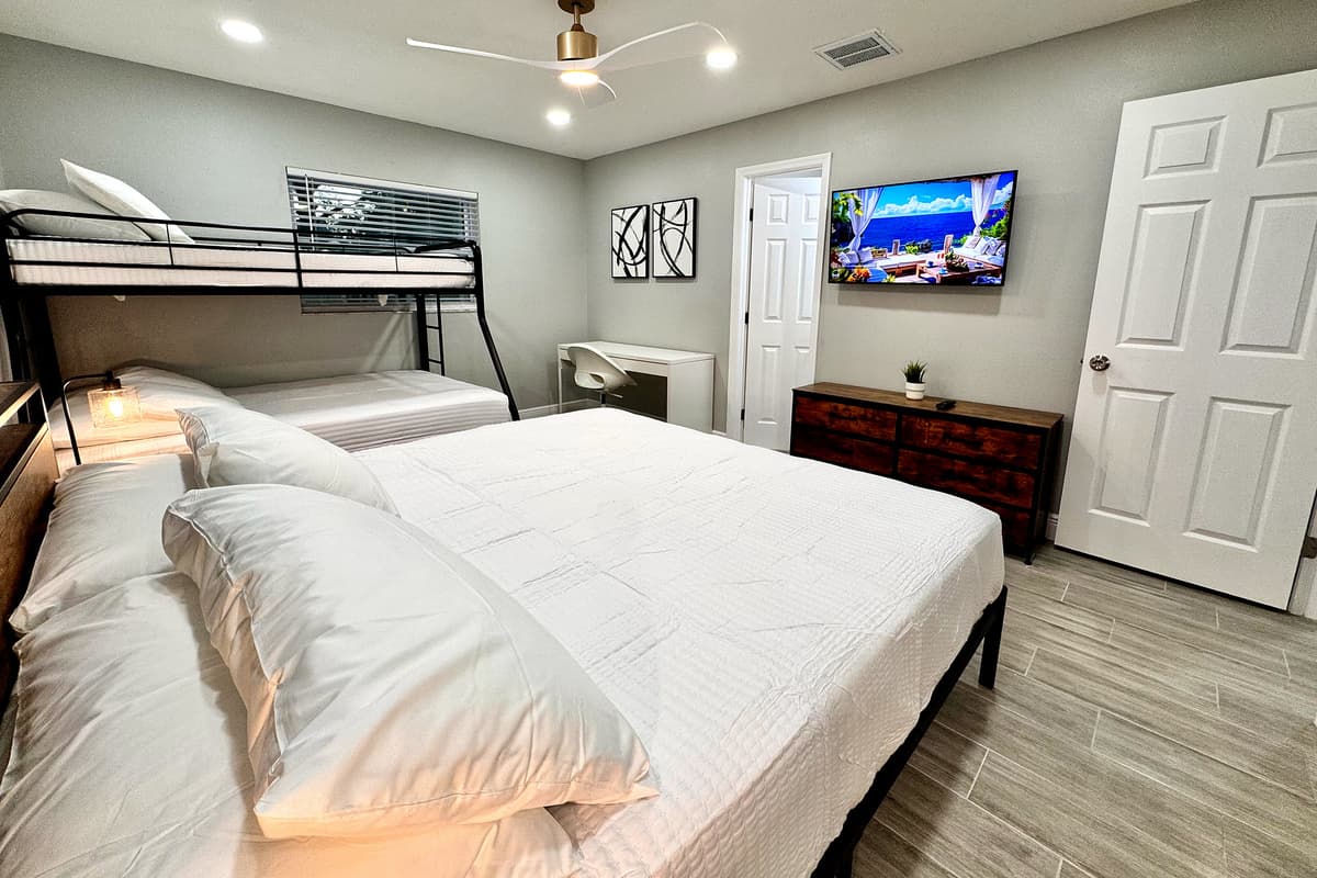 This cozy yet spacious room features a unique sleeping arrangement with a sturdy bunk bed and a plush king-size bed, accommodating various sleeping needs.
