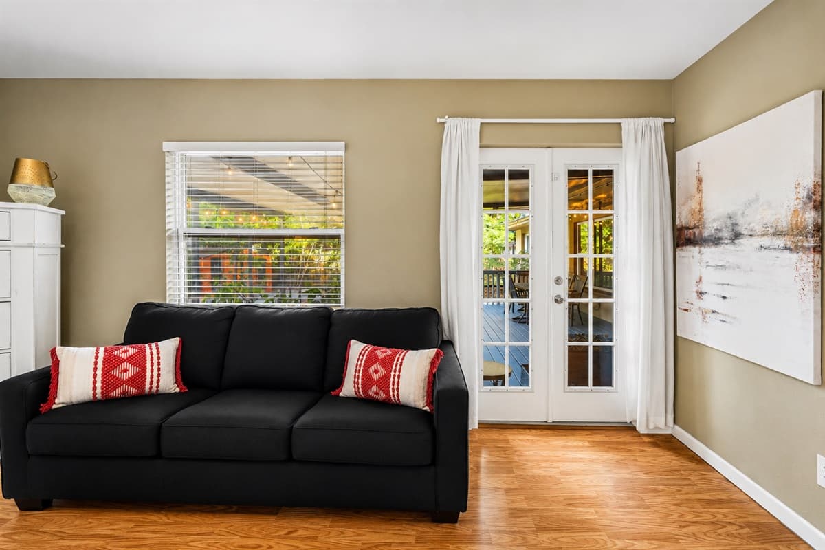 Comfortable bedroom lounge area with a sleeper sofa and direct access to the patio through French doors.