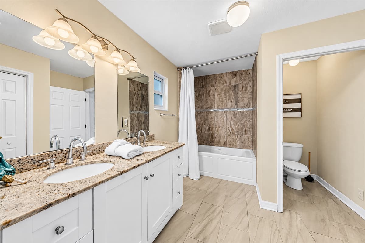 Spacious full bathroom with double vanity, ample counter space, and tub/shower combo.