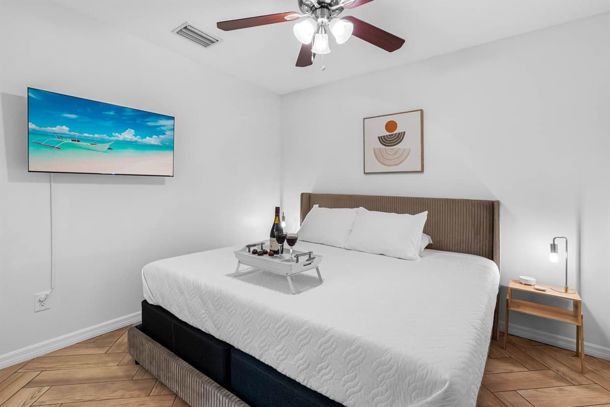 This inviting bedroom features a plush king-size bed, sleek modern decor, and calming tones—perfect for a restful night after a day of exploring Tampa.