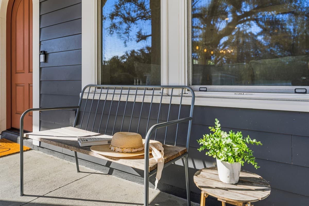 Relax on the front porch with a morning coffee or evening breeze. This welcoming nook features a sleek black metal bench, fresh greenery, and laid-back Seminole Heights charm — grab your hat and enjoy Tampa living at its finest.