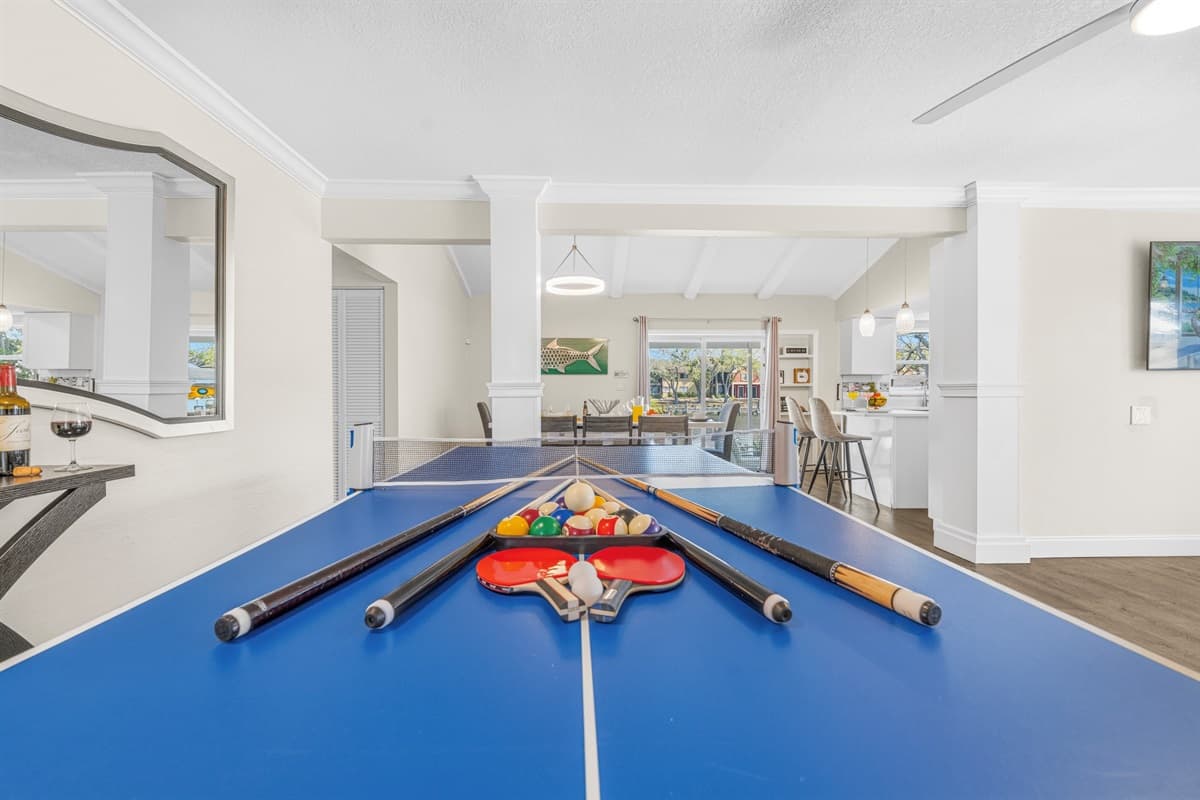 Spacious recreation area with pool table and seamless access to the kitchen and dining room.