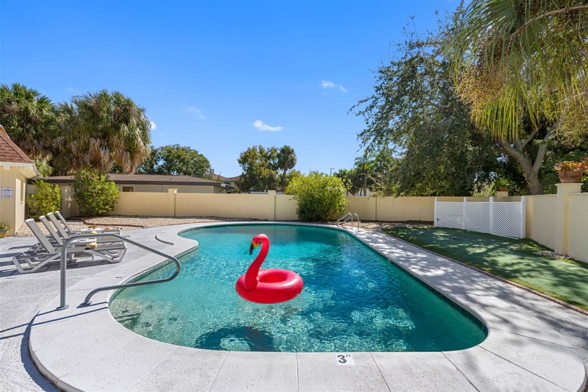 This fully fenced backyard features a sparkling pool, shaded lounge seating, and a BBQ area — your very own slice of paradise in Tampa.