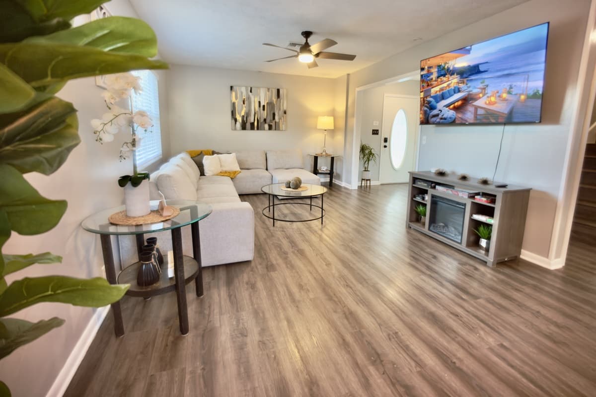 🛋️ Unwind in the stylish living room featuring a large flat-screen TV, ceiling fan, and chic modern décor. Perfect for movie nights or relaxing after a day of Florida fun! 🌿✨