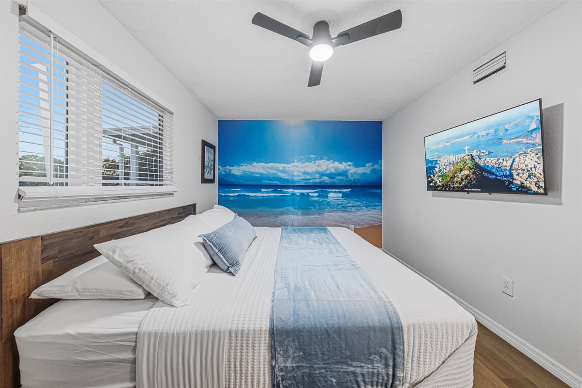 King bedroom with bright windows and ocean-inspired décor for a refreshing, beachy atmosphere 
