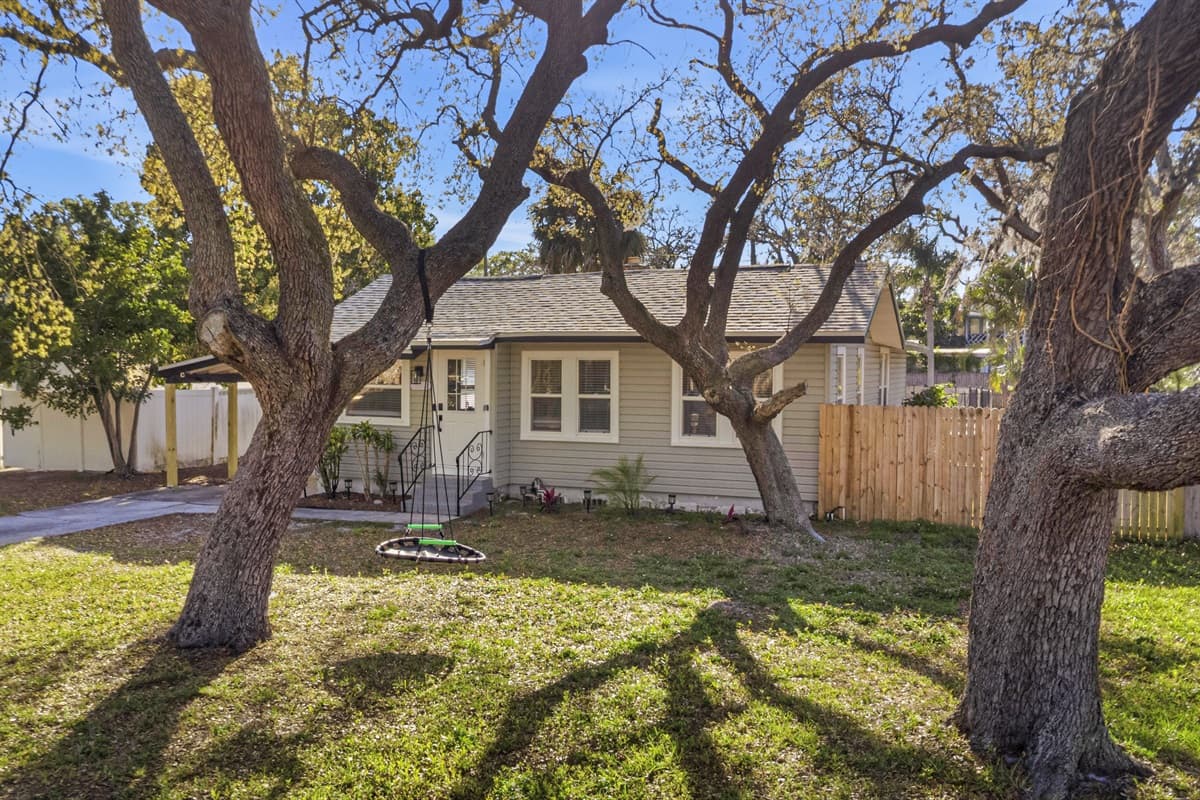 Wide view of the home’s exterior with spacious yard and trees.