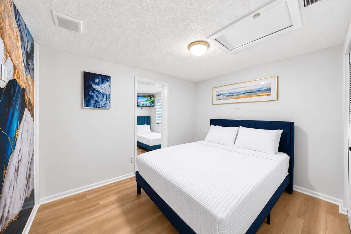 Spacious primary suite with comfortable king bed, contemporary design, and direct access to the ensuite bathroom.