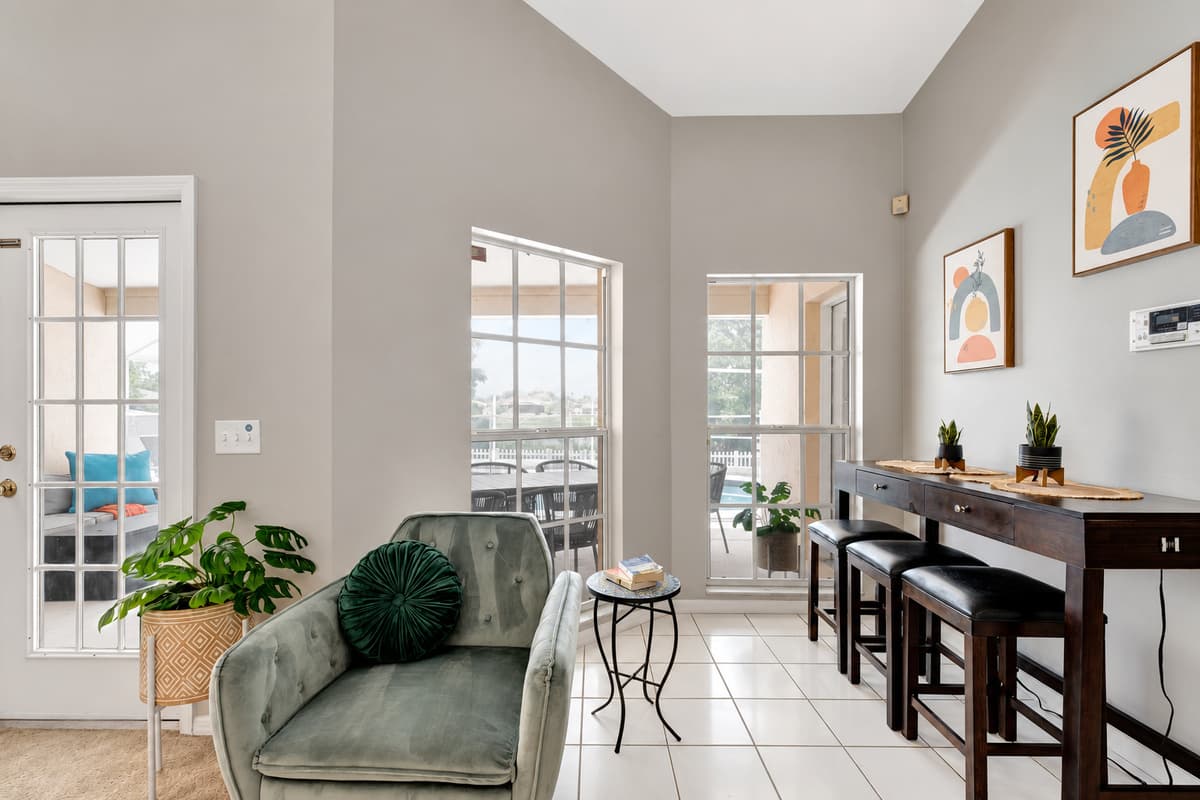 The grandeur of the space is amplified by the expansive floor-to-ceiling windows that flood the room with natural light, creating a seamless connection between the indoors and the beauty of the surrounding landscape.